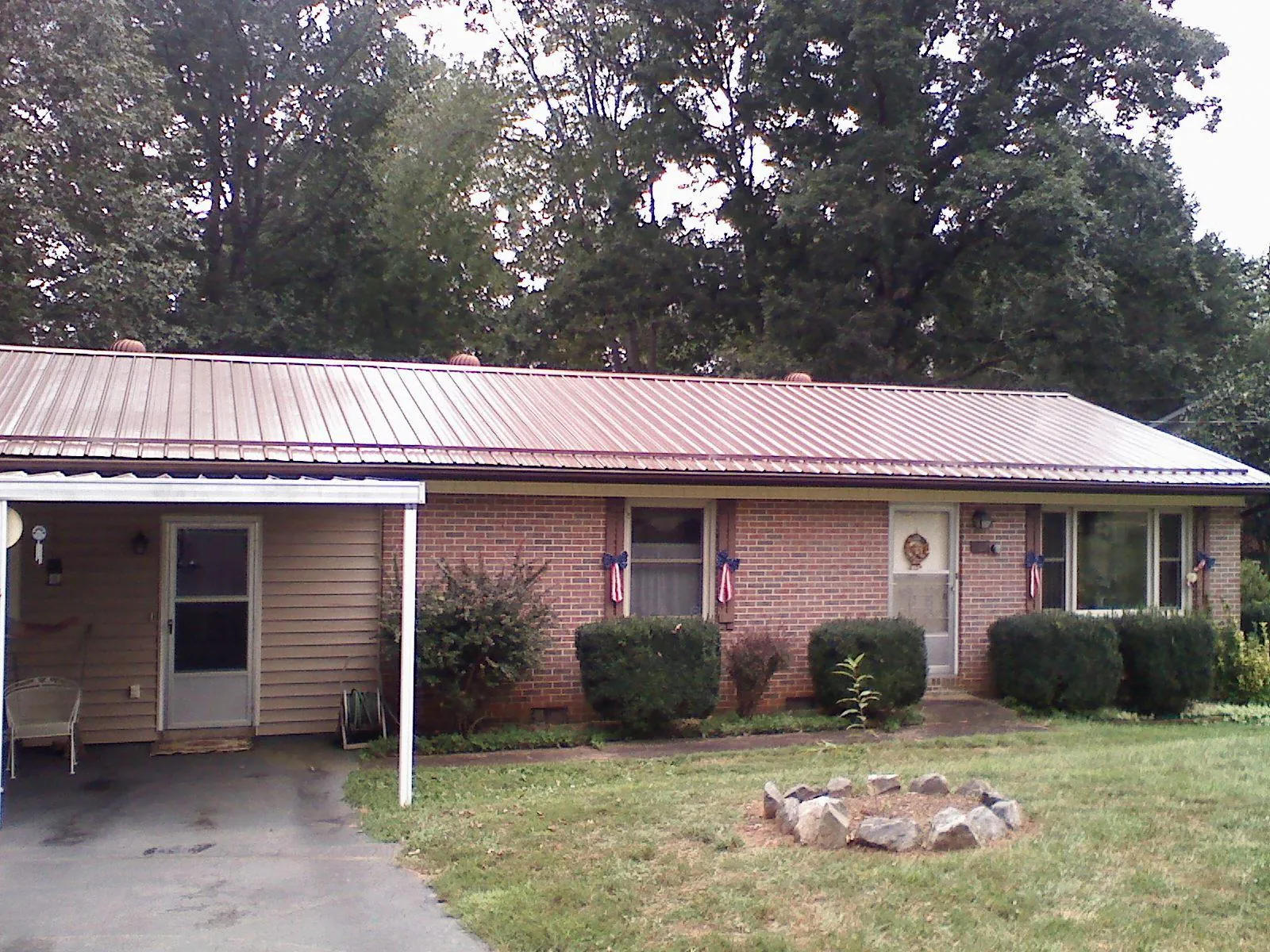 Bronze metal roof and carport on a brick ranch home — Roof Repair work by our crew in El Paso